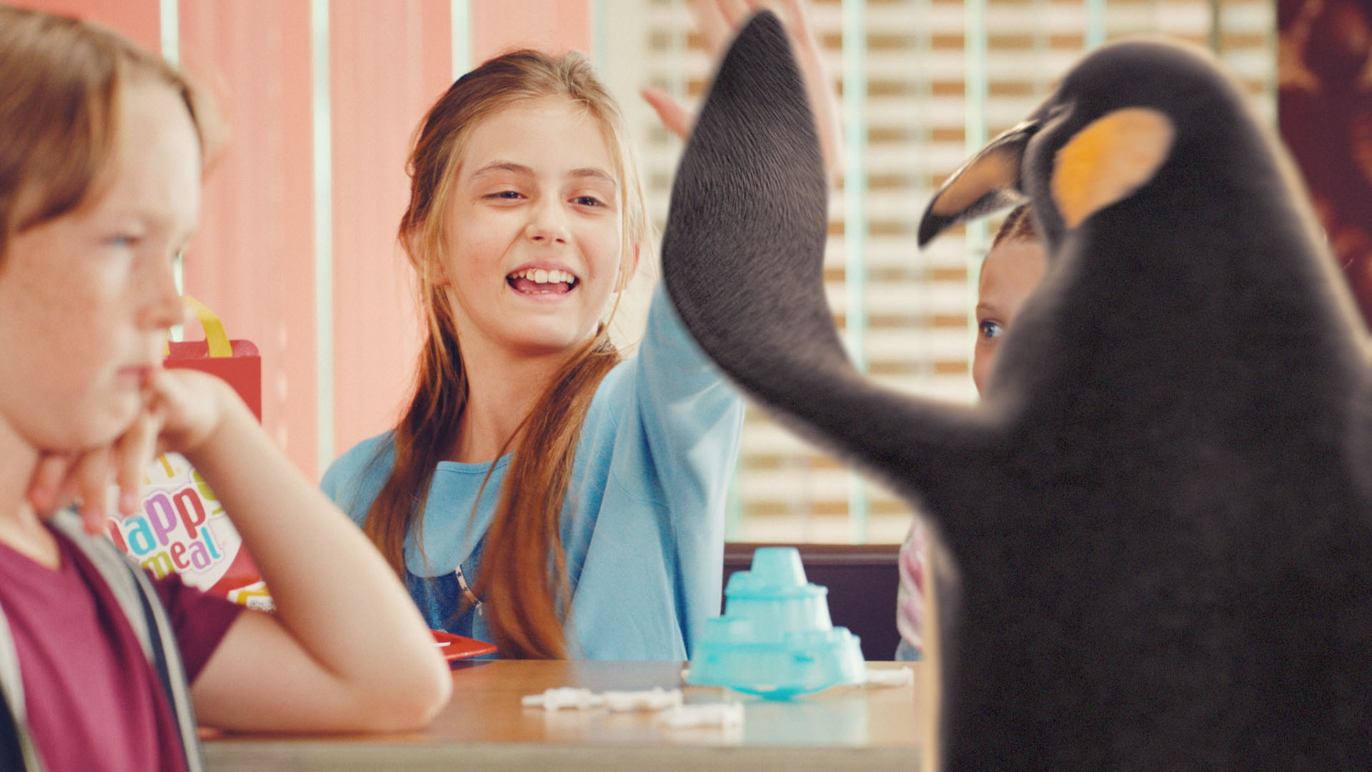 A smiling girl giving our McDonald's VFX penguin "high-five".