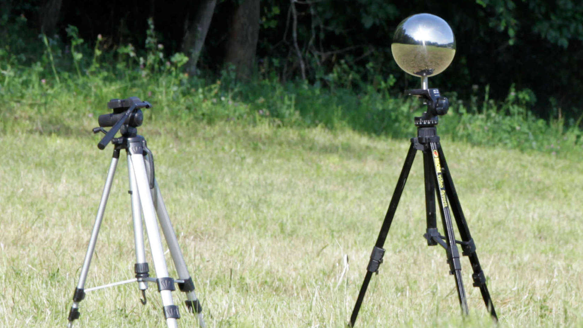 VFX course poster for HDRI Workflows showing a mirrorball HDRI capture rig outside on a meadow on a sunny day. .