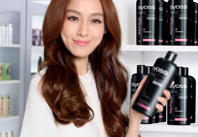 A japanes women in a drugstore happily holding a black Syoss Creatin shampoo bottle which was added using VFX.