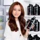A japanes women in a drugstore happily holding a black Syoss Creatin shampoo bottle which was added using VFX.
